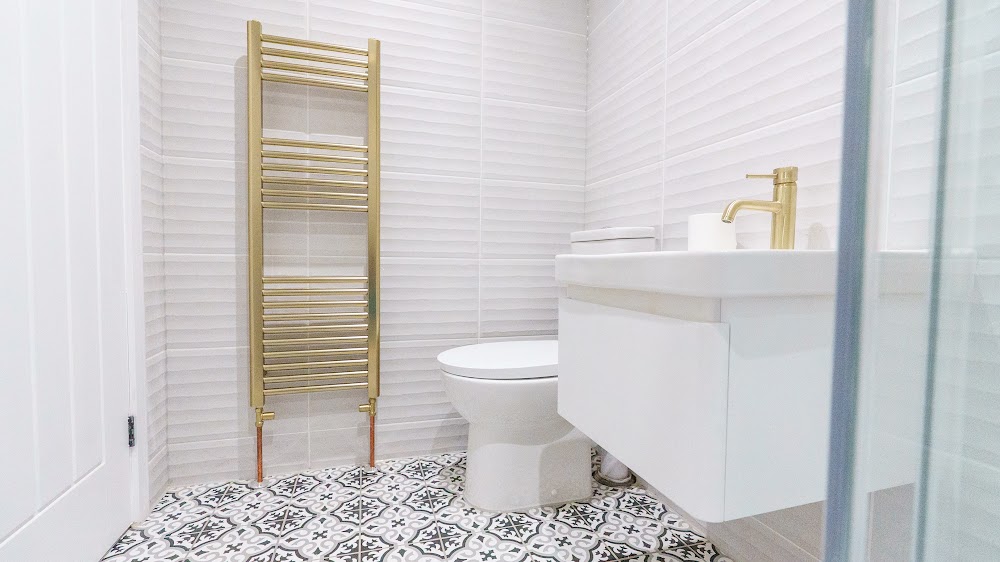 Bathroom with a brass heated towel rail and patterned floor tiles